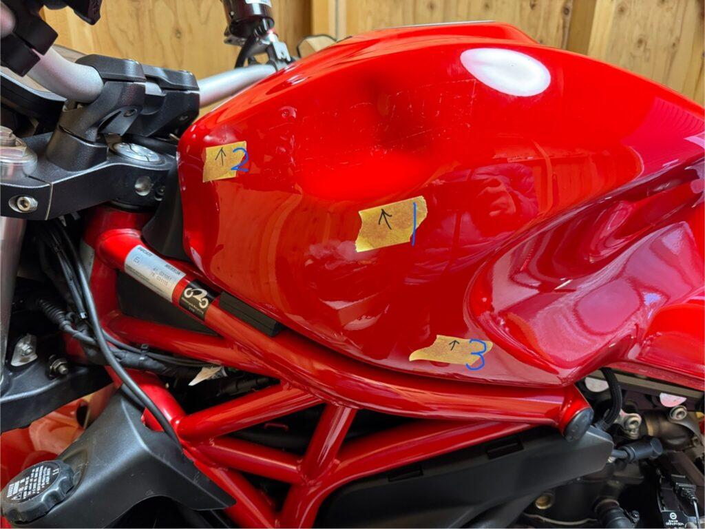 ドゥカティ モンスター1200のバイクタンクをデントリペアで凹み修理前お客様の写真